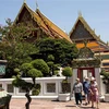 Khách du lịch đeo khẩu trang phòng lây nhiễm COVID-19 khi tham quan một ngôi chùa ở Bangkok, Thái Lan. (Ảnh: AFP/TTXVN) 