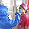 Kiểm tra thân nhiệt của công nhân tại một nhà máy ở Bình Nhưỡng, Triều Tiên, ngày 10/6/2022. (Ảnh: Kyodo/TTXVN) 