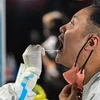 Nhân viên y tế lấy mẫu xét nghiệm COVID-19 cho người dân tại Thượng Hải, Trung Quốc. (Ảnh: AFP/TTXVN) 