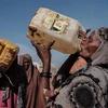 Người dân dùng nước được phân phối tại một trại tạm dành cho người sơ tán do hạn hán nghiêm trọng ở thị trấn thuộc Baidoa, Somalia ngày 13/2/2022. (Ảnh: AFP/TTXVN) 