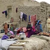 Các em nhỏ ngồi bên cạnh ngôi nhà bị phá hủy do mưa bão tại tỉnh Badghis , Afghanistan ngày 4/5/2022. (Ảnh: THX/TTXVN) 