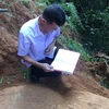 Cán bộ Bảo tàng tỉnh Yên Bái nghiên cứu tổng hợp về những khối đá khắc cổ mới được phát hiện tại thôn Háng Chua Say, xã Chế Cu Nha, huyện Mù Cang Chải. (Ảnh: TTXVN phát) 