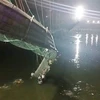 Hiện trường vụ sập cầu treo bắc qua sông Machchu ở thị trấn Morbi, tỉnh Gujarat, miền Tây Ấn Độ, ngày 30/10/2022. (Ảnh: PTI/TTXVN)