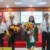 Bà Võ Thị Mỹ Trang và ông Trần Thanh Lâm nhận hoa chúc mừng từ lãnh đạo tỉnh. (Ảnh: Hồng Thái/TTXVN) 