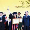 Chủ nhiệm Ủy ban Văn hóa, Giáo dục của Quốc hội Nguyễn Đắc Vinh trao tặng bằng khen cho các thủ khoa. (Ảnh: Minh Đức/TTXVN)