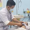 Bác sỹ Dư Tuấn Quy, Trưởng Khoa Nhiễm-Thần kinh, Bệnh viện Nhi đồng 1, Thành phố Hồ Chí Minh, khám cho bệnh nhi viêm màng não. (Ảnh: Đinh Hằng/TTXVN)