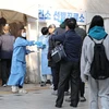 Nhân viên y tế hướng dẫn người dân tại điểm xét nghiệm COVID-19 ở Seoul, Hàn Quốc, ngày 21/11/2022. (Ảnh: Yonhap/TTXVN)