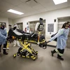 Nhân viên y tế chuyển bệnh nhân COVID-19 tới bệnh viện ở Toronto, Ontario, Canada. (Ảnh: AFP/TTXVN)
