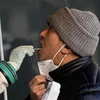 Nhân viên y tế lấy mẫu xét nghiệm COVID-19 cho người dân tại Trung Quốc. (Ảnh: AFP/TTXVN)