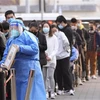 Người dân xếp hàng lấy mẫu xét nghiệm COVID-19 tại Bắc Kinh, Trung Quốc ngày 10/11/2022. (Ảnh: Kyodo/TTXVN)