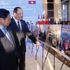 Thủ tướng Phạm Minh Chính và Thủ tướng Lào Sonexay Siphandone tham quan triển lãm. (Ảnh: Phạm Kiên/TTXVN)