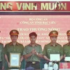 Đại tá Lê Việt Thắng, Giám đốc Công an tỉnh Bạc Liêu (đứng giữa), trao thưởng cho Ban chuyên án. (Ảnh: Hải Linh/TTXVN phát)