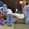 Nhân viên y tế chuyển bệnh nhân COVID-19 tới bệnh viện ở Tokyo, Nhật Bản. (Ảnh: Kyodo/TTXVN) 