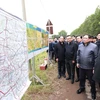 Thủ tướng Phạm Minh Chính xem bản đồ tuyến đường vành đai 4 vùng Thủ đô Hà Nội tại điểm xã Song Phương, huyện Hoài Đức. (Ảnh: Dương Giang/TTXVN)
