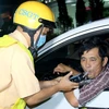 Lực lượng Cảnh sát giao thông kiểm tra nồng độ cồn đối với tài xế lái xe ôtô. (Ảnh: Nguyễn Thanh/TTXVN)