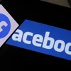 Biểu tượng Facebook trên màn hình máy tính và điện thoại di động. (Ảnh: AFP/TTXVN)