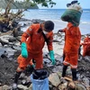 Lực lượng bảo vệ bờ biển và nhân viên tình nguyện dọn dầu loang Pola, tỉnh Oriental Mindoro, Philippines, ngày 8/3/2023. (Ảnh: AFP/TTXVN) 