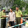 Các cán bộ Trạm Kiểm lâm Việt Hải tuyên truyền nâng cao nhận thức của người dân trong việc bảo vệ, phát triển rừng và khai thác thủy hải sản. (Ảnh: Minh Đức/TTXVN)