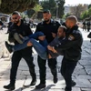 Cảnh sát Israel bắt giữ một người đàn ông Palestine sau các cuộc đụng độ tại khu vực đền Al-Aqsa (mà Israel gọi là Núi Đền) ở Jerusalem ngày 5/4/2023. (Ảnh: AFP/TTXVN)