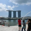 Khách du lịch đeo khẩu trang tại một địa điểm tham quan nổi tiếng của Singapore. (Ảnh: AFP/TTXVN) 
