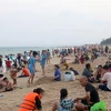 Bãi biển Đồi Dương (thành phố Phan Thiết) đông người dân và du khách trong ngày nghỉ lễ đầu tiên. (Ảnh: Nguyễn Thanh/TTXVN)