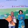 Tổng Giám đốc TTXVN Vũ Việt Trang trao Giải thưởng lớn “Hiệp sỹ Dế mèn” và chứng nhận cho nhà văn Trần Đức Tiến với truyện dài “A lô! Cậu đấy à.” (Ảnh: Hoàng Hiếu/TTXVN)