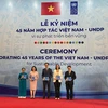 Trưởng đại diện thường trú UNDP tại Việt Nam trao Sách ảnh 45 năm quan hệ đối tác Việt Nam-UNDP vì Phát triển bền vững cho đại diện lãnh đạo các bộ, ngành. (Nguồn: Báo Nhân Dân)