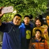 Cả gia đình cùng chụp ảnh lưu niệm tại Hồ Gươm trước thời khắc đón giao thừa, bước sang Năm mới. (Ảnh: Tuấn Đức/TTXVN)