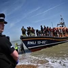 Người di cư tới bờ biển tại Dungeness, Anh, sau khi được giải cứu khi vượt eo biển Manche, ngày 15/3/2022. (Ảnh: AFP/TTXVN)