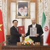 Chủ tịch Quốc hội Vương Đình Huệ và Chủ tịch Quốc hội Iran Mohammad Bagher Ghalibaf ký thỏa thuận hợp tác giữa Quốc hội hai nước. (Ảnh: Doãn Tấn/TTXVN)