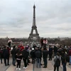 Khách du lịch chụp ảnh bên Tháp Eiffel ở thủ đô Paris, Pháp. (Ảnh: AFP/TTXVN)