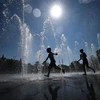 Trẻ em làm mát tại đài phun nước ở Colmar, miền Đông Pháp ngày 21/8/2023. (Ảnh: AFP/TTXVN)