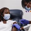 Nhân viên y tế tiêm vaccine ngừa COVID-19 cho người dân tại New York, Mỹ . (Ảnh: AFP/TTXVN)
