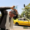Một người đàn ông đổ nước lên đầu giải nhiệt dưới trời nắng gắt tại Tehran, Iran ngày 11/7/2023. (Ảnh: AFP/TTXVN)