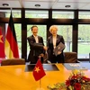 Tiến sỹ Phạm Hoàng Mai, Vụ trưởng Vụ Kinh tế Đối ngoại, Bộ Kế hoạch và Đầu tư và bà Gisela Hammerschmidt, Vụ trưởng Vụ châu Á, Cao ủy viên đặc trách châu Á của BMZ ký thỏa thuận. (Ảnh: Mạnh Hùng/TTXVN)
