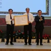 Phó Thủ tướng Chính phủ Trần Lưu Quang trao Quyết định của Thủ tướng Chính phủ phê duyệt Quy hoạch tỉnh Kiên Giang thời kỳ 2021-2030, tầm nhìn đến 2050 cho lãnh đạo tỉnh Kiên Giang. (Ảnh: Lê Huy Hải/TTXVN)
