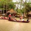 Du khách trải nghiệm chèo thuyền trên sông ở Làng du lịch Mỹ Khánh. (Ảnh: Thu Hiền/TTXVN)