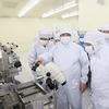 Thủ tướng Phạm Minh Chính thăm dây chuyền sản xuất của Công ty sản xuất chip bán dẫn tại Bắc Giang. (Ảnh: Dương Giang/TTXVN)