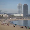 Người dân tắm mát trên bãi biển ở Barcelona, Tây Ban Nha. (Ảnh: AFP/TTXVN)