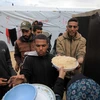 Người dân nhận thực phẩm cứu trợ tại thành phố Rafah, Dải Gaza ngày 18/3/2024. (Ảnh: THX/TTXVN)