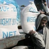 Người dân Palestine nhận lương thực viện trợ từ Cơ quan cứu trợ người tị nạn Palestine của Liên hợp quốc (UNRWA) tại một trại tị nạn ở Rafah, Dải Gaza. (Ảnh: AFP/TTXVN)