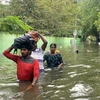 Người dân sơ tán khỏi vùng ngập lụt sau những trận mưa lớn do ảnh hưởng của bão Michaung tại Chennai, Ấn Độ, ngày 5/12/2023. (Ảnh: AFP/TTXVN)
