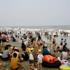 Du khách và người dân địa phương dồn về Bãi biển Sầm Sơn tránh nóng. (Ảnh: Hoa Mai/TTXVN)