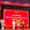 Đại tá Vũ Như Hà (bên trái) nhận quyết định và hoa của lãnh đạo Bộ Công an. (Nguồn: Cổng Thông tin Điện tử Chính phủ)