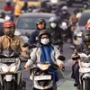Người dân đeo khẩu trang tránh khói bụi trên một tuyến đường ở Jakarta, Indonesia. (Ảnh: AFP/TTXVN)