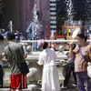 Người dân tránh nóng bên đài phun nước tại Bắc Kinh, Trung Quốc. (Ảnh: THX/TTXVN)