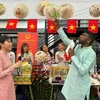 Ban tổ chức thích thú giới thiệu về nón lá Việt Nam. (Ảnh: Đỗ Vân/TTXVN)