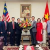 Đại sứ Lào tại Malaysia Thepthavone (thứ 5, bên trái) tặng hoa cán bộ, nhân viên Đại sứ quán Việt Nam. (Ảnh: Thành Trung/TTXVN)