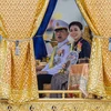 Đương kim Quốc vương Thái Lan Maha Vajiralongkorn (Vua Rama X) và Hoàng hậu Suthida ngồi trên thuyền rước hoàng gia. (Ảnh: Đỗ Sinh/TTXVN)