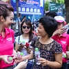 Với khẩu hiệu ‘giải cứu mùa hè’, MC Phan Anh cùng Hoa hậu Jennifer Phạm đã cùng nhau phát hàng ngàn chiếc khăn ướt cùng nước mát cho người dân trên khắp Thủ đô. (Ảnh: Minh Sơn/Vietnam+)